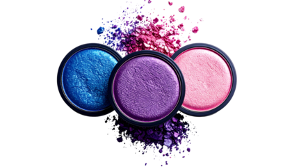 Three colorful eyeshadow compacts with scattered pigment against a black background