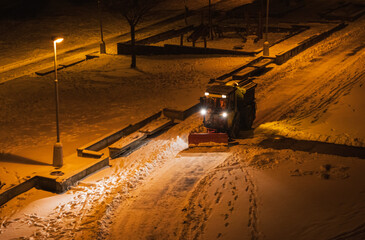 Winter street maintenance, snow removal during the night. The city's service vehicle maintains safety and order during snowstorms