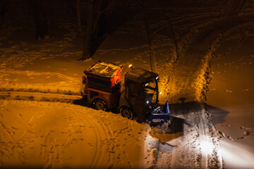 Winter street maintenance, snow removal during the night. The city's service vehicle maintains safety and order during snowstorms