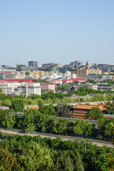 Fototapeta premium Beijing,Aerial view of a cityscape with traditional architecture surrounded by greenery and modern buildings under a clear sky