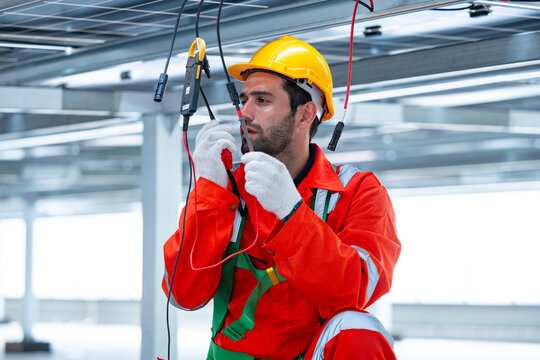 Technician testing solar panel electrical connection