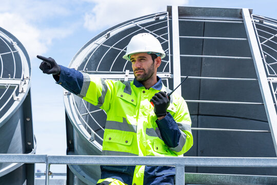 Technicians discussing HVAC system on rooftop