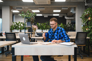 Man working on laptop in modern coworking office