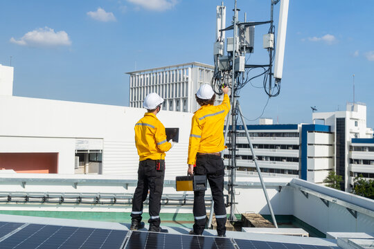 Engineers inspecting rooftop telecommunications tower