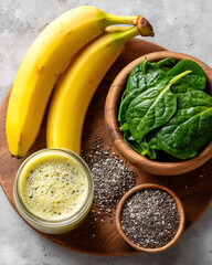 Banana, spinach and chia seeds arranged on bright countertop, ingredients for green smoothie