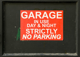 Naklejka premium garage no parking sticker on black metal door, day and night warning