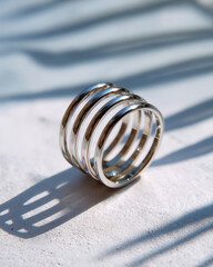 Stainless steel ring with mirror finish and soft shadow on bright neutral surface