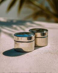 Two overlapping stainless steel cylinders with soft shadows on bright reflective surface