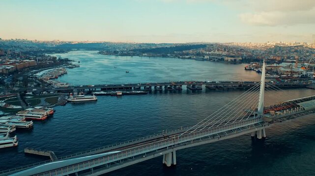 Halic Metro Bridge aerial view of the modern transit bridge over Golden Horn. Cinematic drone flight showing the metro station and Istanbul skyline.