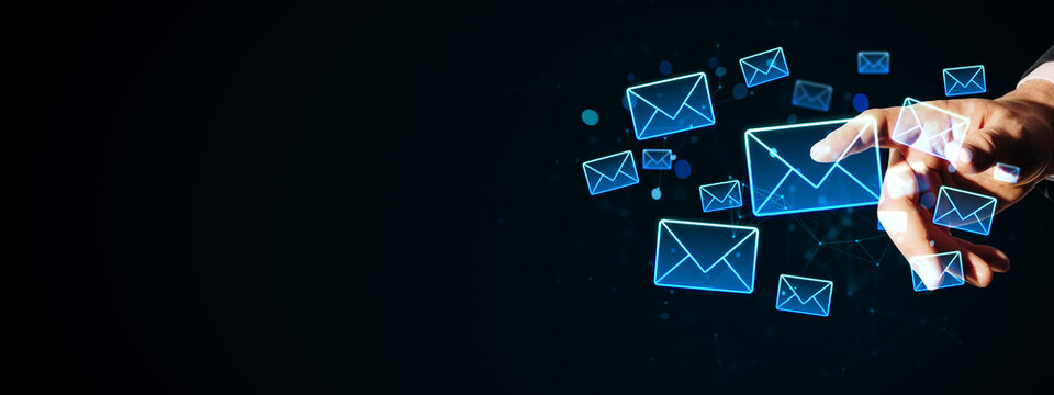 Hand interacting with glowing email icons in digital network communication concept on dark background with futuristic interface elements.