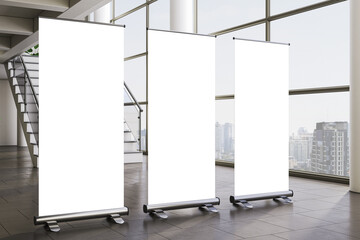 Blank vertical roll-up banner mockup set in modern office interior with large windows overlooking cityscape and staircase background. 3D Rendering