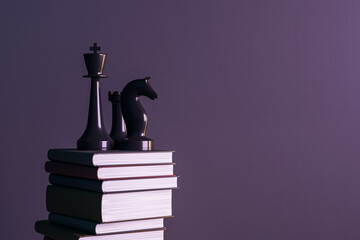 Glossy black chess pieces on stacked hardcover books against purple background symbolizing knowledge, power, and strategy in education. 3D Rendering