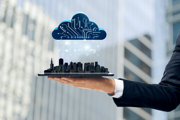 Businessman holding tablet with digital cityscape and cloud computing symbol above, symbolizing smart city and data technology concept..