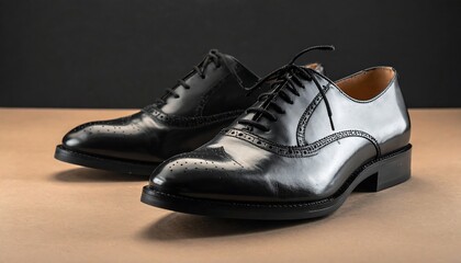 Pair of glossy black leather oxford shoes displayed on a neutral surface against a dark background