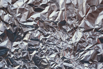 Crumpled aluminum foil showing shiny metallic texture and abstract patterns