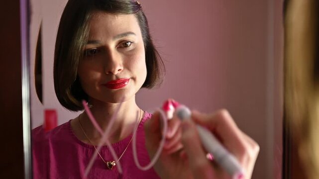 Girl Writing &ldquo;XO XO&rdquo; on a Mirror for Valentine&rsquo;s Day symbolizing hugs and kisses, affection, and playful romantic communication. Romantic love note concept, relationships and heartfelt messages.