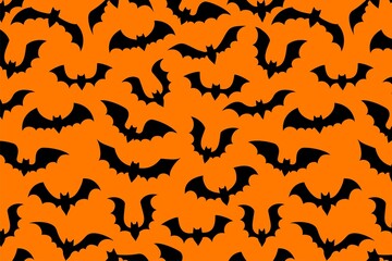 Spooky Halloween bats flying on orange background