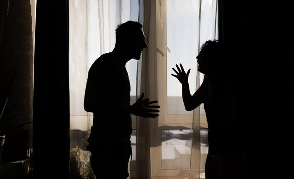 Silhouetted Dispute: Couple in Conflict During a Home Quarrel.