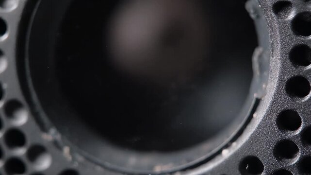 Extreme Close-Up of a Black Speaker Grill with Subtle Dust Particles and Reflections, Macro Shot