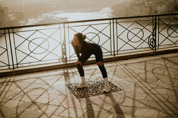 Woman exercises by the waterfront in Malta during early morning hours