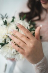 Close up of the bride's hands holding a bouquet of flowers. Bridal bouquet, hold the wedding bouquet in your hand
