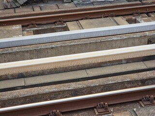 Industrial Steel Staircase at a Modern Public Transit Station. A side view of an outdoor staircase featuring heavy-duty steel construction and green metal handrail supports. 