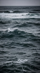 Fototapeta premium Dark ocean water with small waves and foam, creating an undulating surface, representing nature's power and movement, a calming yet dynamic scene