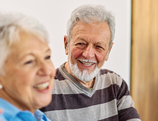 Portrait of a happy senior couple embracing hugging and bonding at home