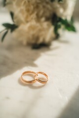 Wedding rings on the wedding bouquet of white roses