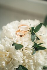 Wedding rings on the wedding bouquet of white roses