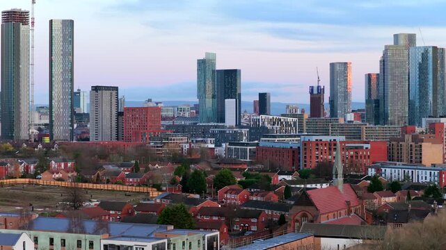 Aerial video of Manchester city center skyline, showcasing the Deansgate Square towers and the ongoing high-rise construction at sunset.