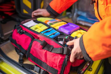 A paramedic is checking the supplies in medical bag, ensuring everything is fully stocked and ready for emergency