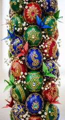 Fototapeta premium Arrangement of red, green, blue ornamented spheres and origami crane, embellished with small white flower, representing handcrafted artistry, and elegance