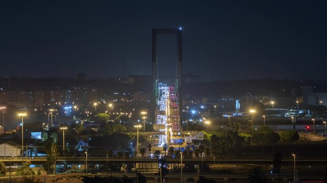 Night traffic timelapse crossing Puente del Centenario bridge in Seville with light tra