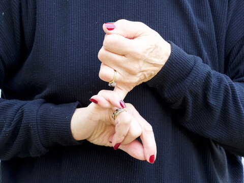 A pair of hands signing the consonant letter 'S' in British Sign Language.BSL.Communication.Hearing Impaired.