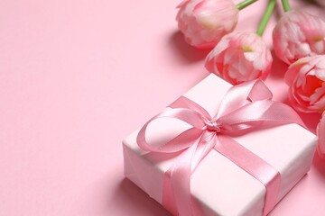 Beautiful fresh tulips with gift box card on pink background