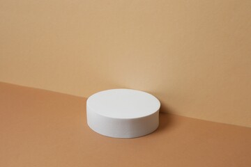 White round podium with smooth, textured surface under soft tones. Ideal for product mockups, cosmetic displays, or minimal brand presentations. 3D rendering