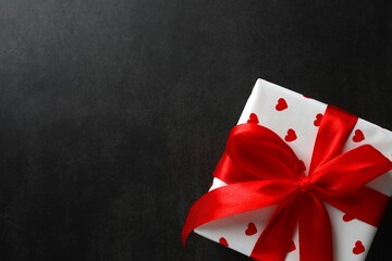 Festive gift box with red hearts on black background. St.Valentine's Day