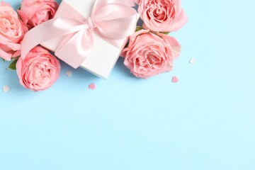 Festive composition with pink roses and gift box on color background. Ideal for Valentine's Day, 8 March, Birthday or other holidays