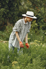 Woman in a hat gardening in her backyard