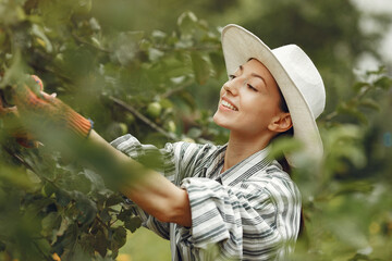 Woman in a hat gardening in her backyard