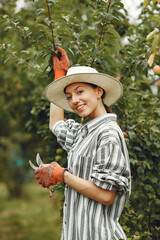 Woman in a hat gardening in her backyard