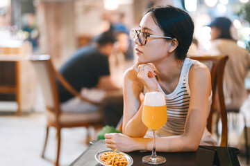 Portrait of single young adult asian lonely woman drinking beer at bar alone lifestyle with alcohol