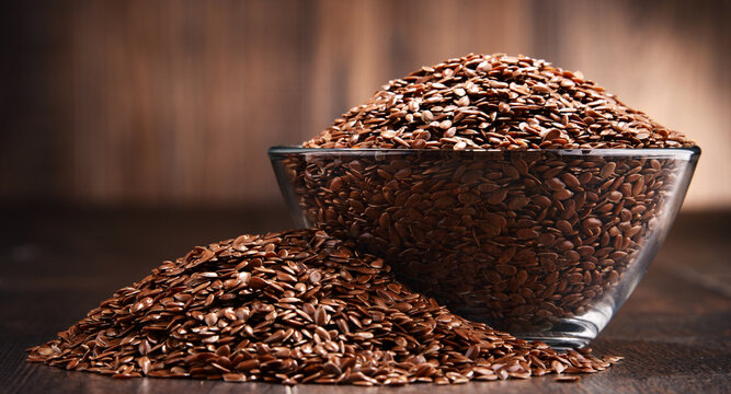 Composition with bowl of flax seeds on wooden table