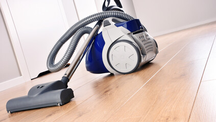 Canister vacuum cleaner for home use on the floor panels
