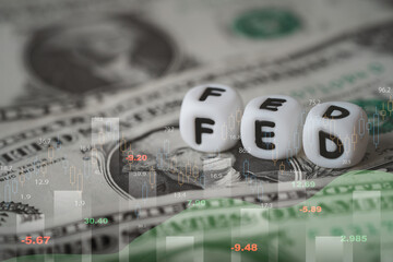 FED dice on US dollar banknotes with financial market chart represent Federal Reserve interest rate decision for inflation control, monetary policy, economic slowdown and global uncertainty concept