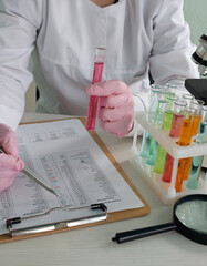 Scientist conducts experiments with test tubes in a laboratory setting during daylight hours