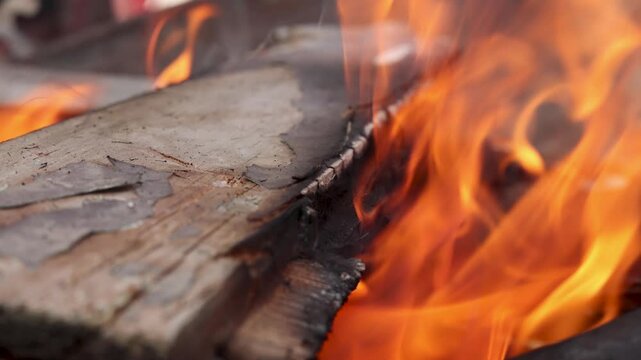 Wood burns with bright flames, showing warmth, heat, and traditional fire use during cold winter conditions in a simple rural Indian environment.