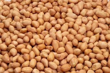 A macro close-up texture of a raw heap of white beans and dry organic peanuts creates a healthy,...