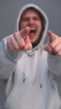 An adult man mocks and humiliates someone.
Mocking and bullying.
A man points at a person and laughs at them.